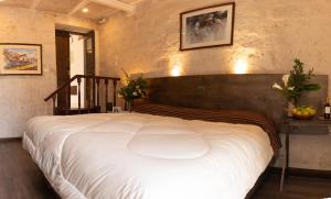 a bedroom with a large white bed with a wooden headboard at Acolpacha Tambo Boutique in Arequipa