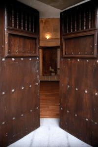 an empty room with two large wooden doors at Acolpacha Tambo Boutique in Arequipa