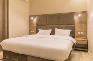 a bedroom with a large bed with white sheets and pillows at فندق وفود in Rafha