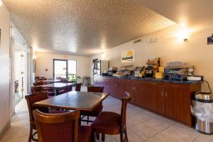 een restaurant met een tafel en stoelen en een bar bij Days Inn by Wyndham Kuttawa/Eddyville in Kuttawa