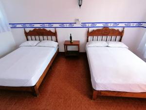 dos camas sentadas una al lado de la otra en una habitación en Don Luis Hostal - Sucursal Galeana - Tecolutla en Tecolutla