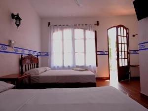 A bed or beds in a room at Don Luis Hostal - Sucursal Galeana - Tecolutla