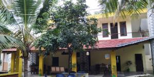 un edificio con sillas y árboles delante de él en Holiyday in VGF Farm House, en Dānishpet