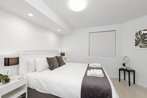 a hotel room with a bed, chair, and nightstand at Alexandria Apartments in Alexandra Headland