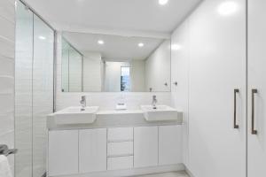 a bathroom with a sink and a mirror at Alexandria Apartments in Alexandra Headland