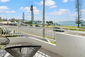 a balcony with two chairs and a view of the ocean at Alexandria Apartments in Alexandra Headland