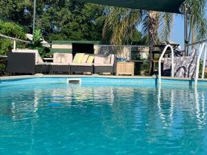 a swimming pool with a couch and a swimming pool at Evanston Station in Ilfracombe