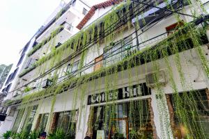 um edifício coberto de muitas janelas e videiras em Leaf Signature Hotel - Lá Group em Ho Chi Minh