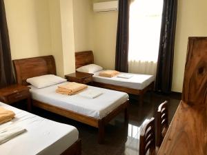 a room with three beds and a window at Lucena Fresh Air Hotel in Lucena