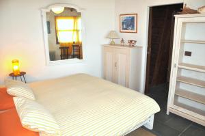 een kamer met een bed, een spiegel en een deur bij Pico Hincado Rural House in Alajeró