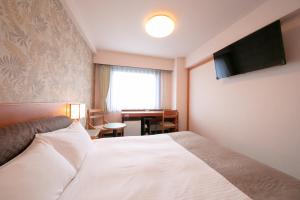 Una habitación de hotel con una cama y un televisor de pantalla plana. en Green Hotel Yes Ohmi-hachiman, en Omihachiman