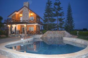 una casa con piscina di fronte a una casa di WIND of LOVE a Ban Tha Chang
