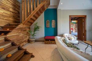 a living room with a couch and wooden stairs at Menzel Ubud in Ubud
