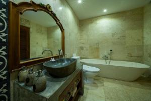 a bathroom with a sink and a tub and a toilet at Menzel Ubud in Ubud
