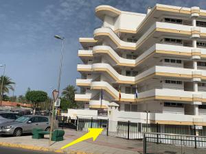 a building with a yellow arrow in front of it at Aloe Friendly Holiday Home in Playa del Ingles