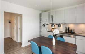 eine Küche und ein Esszimmer mit einem Holztisch und blauen Stühlen in der Unterkunft Nice Apartment In Rechlin With Wifi in Rechlin