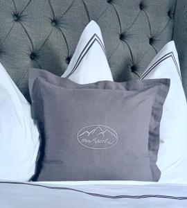 ein schwarzes Kissen auf einem Bett mit weißen Kissen in der Unterkunft INN Apart Tirol in Innsbruck