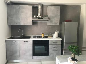 una cucina con piano cottura e frigorifero di Homelyfeeling a Castelnuovo del Garda