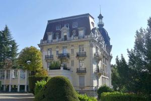 a building with a clock on the top of it at Magnifique Appartement dans palace Belle Époque in Aix-les-Bains