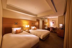 a hotel room with two beds and two lamps at Marunouchi Hotel in Tokyo