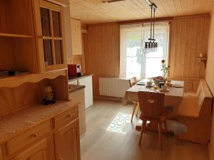 uma cozinha com uma mesa e uma sala de jantar em Ferienwohnung Antonia em Surcuolm