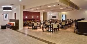 Holiday Inn Charlotte Airport, an IHG Hotel في تشارلوت: مطعم فيه طاولات وكراسي في الغرفة