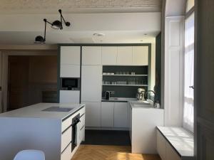 a kitchen with white cabinets and a white counter top at Magnifique Appartement dans palace Belle Époque in Aix-les-Bains