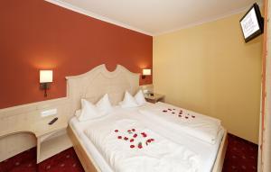 a bedroom with a white bed with red roses on it at Hotel-Restaurant Früchtl in Zandt +25 photos