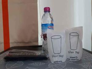 een fles water en een zak op een tafel bij บ้านเล็ก รีสอร์ท in Prachuap Khiri Khan