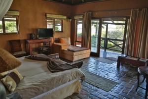 a bedroom with a bed and a living room at Waterside Lodge in Wilderness
