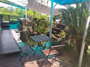 a deck with two chairs and a table and a pond at บ้านเล็ก รีสอร์ท in Prachuap Khiri Khan