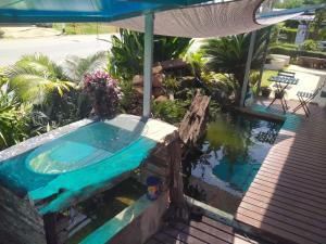 an outdoor swimming pool with an umbrella and a swimming pool at บ้านเล็ก รีสอร์ท in Prachuap Khiri Khan