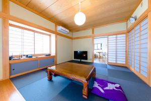 富士河口湖的住宿－iine，客厅配有桌子和电视