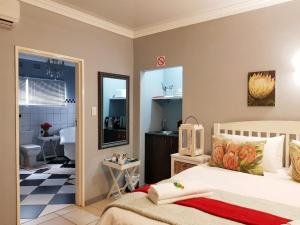a bedroom with a bed and a bathroom at Graceland Guesthouse in Potchefstroom