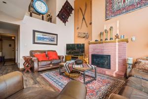 a living room with couches and a brick fireplace at Vantage Point #408 Condo in Vail