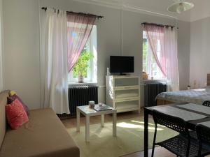 uma pequena sala de estar com uma cama e uma televisão em Négy évszak Apartman- Tapolca em Tapolca