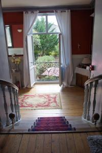 - une porte ouverte menant à une chambre avec un tapis au sol dans l'établissement Les remparts de la Bastide, à Castillonnès