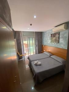 1 dormitorio con 2 camas y toallas. en Hostal Drassanes, en Barcelona