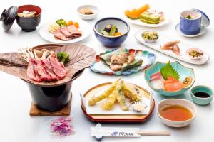 una mesa con platos de comida y tazones de sopa en Hotel Tagawa, en Yamanouchi