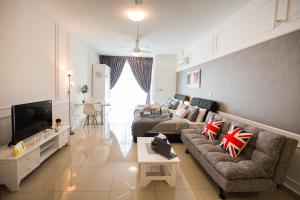 ein Wohnzimmer mit einem Sofa und einem TV in der Unterkunft Twin Galaxy Residences By The One in Johor Bahru