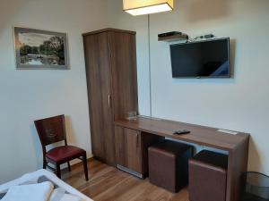 a hotel room with a desk and a tv at Viktória Lovas Panzió in Győr