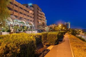 un parco con panchina di fronte a un edificio di Faleza Hotel by Vega a Galaţi