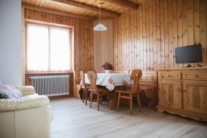 ein Esszimmer mit einem Tisch, Stühlen und einem TV in der Unterkunft Agritur Rizzi di Inama Ugo in Coredo