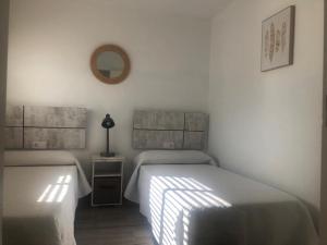 PARADISE FUERTEVENTURA في مورو جابل: غرفة نوم بسريرين ومرآة على الحائط