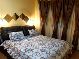 a bedroom with a bed with a blue and white comforter at CEMPAKA IRIS HOMESTAY in Kampung Bota Kiri +5 photos