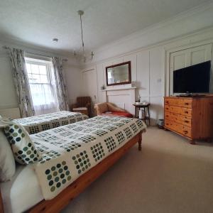 a bedroom with two beds and a flat screen tv at Moraybank Bed & Breakfast in Elgin