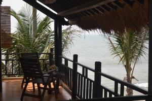 eine Veranda mit einem Stuhl und Meerblick in der Unterkunft Rang Garden Beach Side in Mui Ne