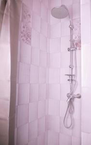a shower with pink tiled walls and a shower head at Mas de la Croix - Chambres d'hôtes in Sernhac