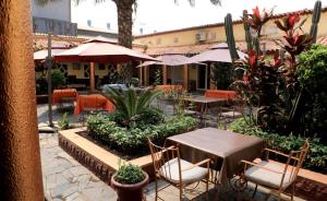 卢本巴希Park Hotel的有桌椅和遮阳伞的户外餐厅