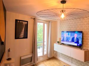 a living room with a flat screen tv and a window at Hullman Suite Apartment 4 People Between La Défense and Paris in Asnières-sur-Seine